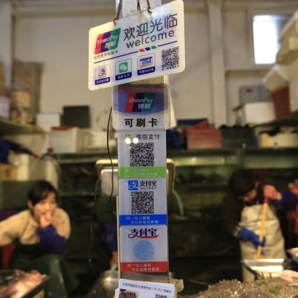 Placards on a seafood stall show various non-cash ways to pay which include Unionpay cards, and QR codes of Wechat and Alipay at a market in Beijing, China, 11 April 2016. China's consumer prices remain strong in March, driven mainly by rising vegetable and pork prices. The consumer price index (CPI), a main gauge of inflation, was at 2.3 per cent in March, according to the National Bureau of Statistics on 11 April 2016. Photo: EPA