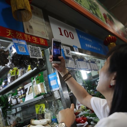 A woman scans an Alipay QR code to make a payment via her mobile phone in a market in Beijing, China, 09 August 2017. Even though it started late, China now has the world’s largest cashless economy, where two services -- Ant Financial’s Alipay and Tencent Holdings’ WeChatPay -- dominate the US$5.5 trillion market. Photo: EPA