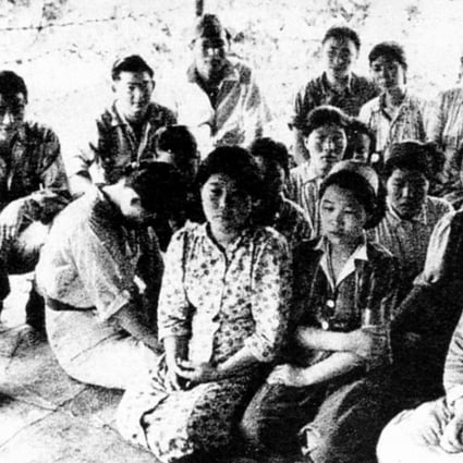 Young Chinese “comfort women” are pictured sitting with Japanese soldiers during the second world war. It is not known what year this image was taken.