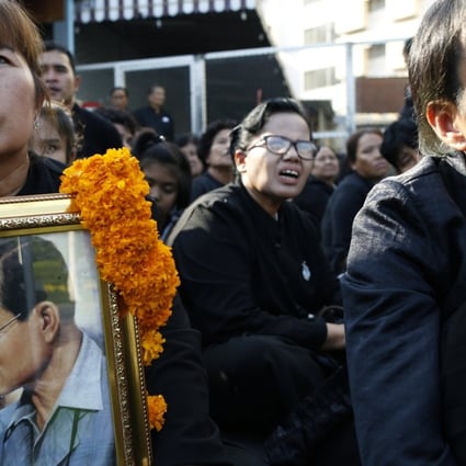 Thai mourners carry photos of late Thai King Bhumibol Adulyadej as they line up at the Royal Crematorium to attend the final cremation ceremony. Photo: EPA