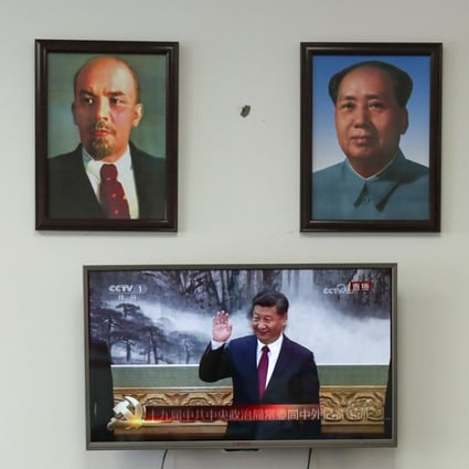 Framed portraits of German philosopher Karl Marx, Soviet state founder Vladimir Lenin and China's late leaders Mao Zedong and Deng Xiaoping (L-R) hang above a screen showing a news broadcast of China's President Xi Jinping attending a meeting in Beijing, as party members gather to watch the broadcast in Wenzhou, Zhejiang province, China October 25, 2017. Photo: Reuters