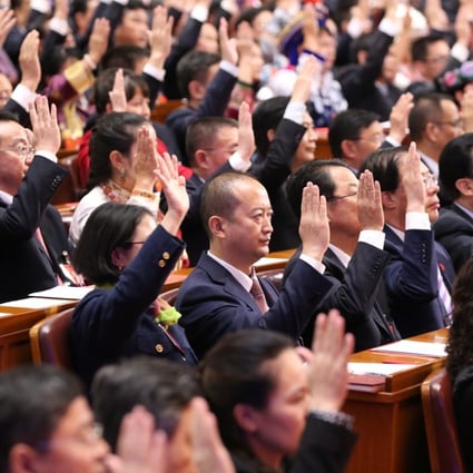Delegates raise their hands during the closing session of the 19th National Congress of the Communist Party of China on Tuesday. Photo: Xinhua