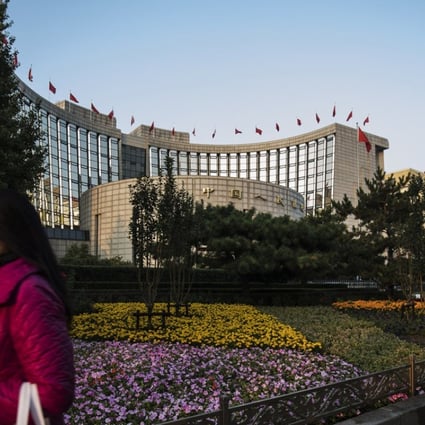 A pedestrian walks past the People's Bank of China headquarters in Beijing, China, on Monday, October 23, 2017. China's central bank is said to have gauged demand for 63-day reverse repurchase agreements for the first time ever. Photo: Bloomberg