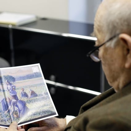 Jean Jacques Bauer, looks at a reproduction of a valuable Pissarro painting he recovered. A Paris court has ordered an American couple to return a valuable Camille Pissarro painting looted during World War II to the descendants of a French family who owned it at the time. Photo: AP