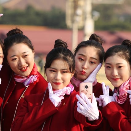 Hotel attendants for delegates pose in Tiananmen Square as the 19th party congress closed on October 24. Photo: Simon Song