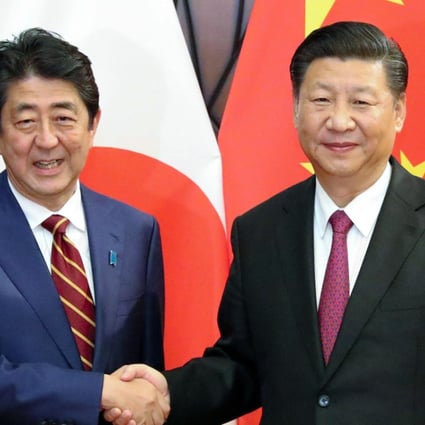 Chinese President Xi Jinping (right) shakes hands with Japanese Prime Minister Shinzo Abe in Da Nang, Vietnam, on Saturday. Xi said China and Japan should do more to improve ties. Photo: Kyodo