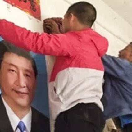 Men put up a poster of Chinese President Xi Jinping in a home in Yugan county, southern China’s Jiangxi province. The local government has launched a campaign to “transform believers in religion into believers in the party”. Photo: Lvv2.com