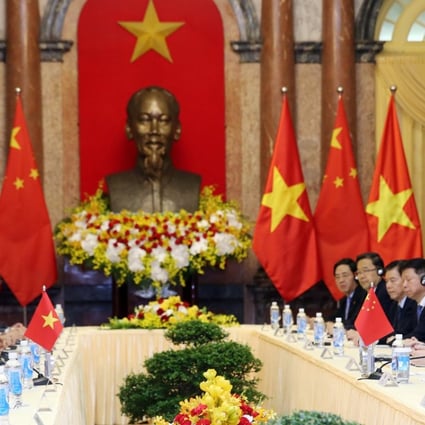 Chinese President Xi Jinping (right) listens as Vietnamese President Tran Dai Quang speaks at the Presidential Palace in Hanoi on Monday. Photo: Reuters