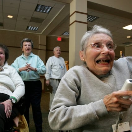 Retirement centre residents react to playing a video game. A new study has shown that the risk of dementia could be reduced by playing video games that exercise the brain. Photo: AFP