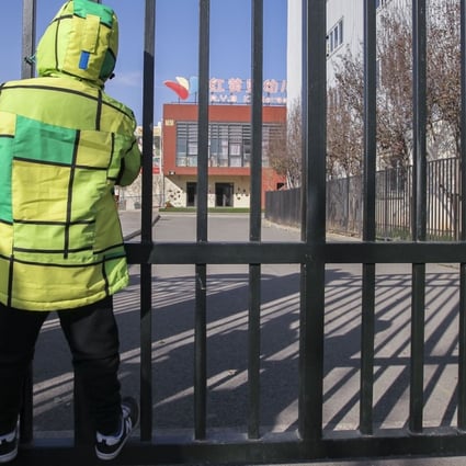 A boy looks through the gates of the RYB Education New World kindergarten in Beijing on Friday. Photo: Simon Song