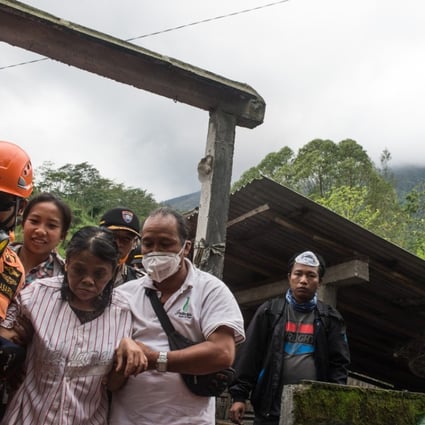 Rescuers evacuate a family at the Ban Village in Karangasem district. Photo: Xinhua