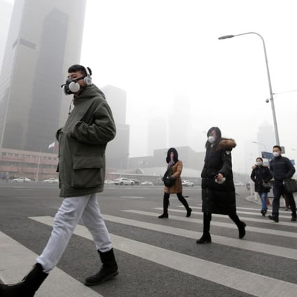 Pedestrians wear masks as thick smog blankets Beijing in December last year. Photo: Reuters