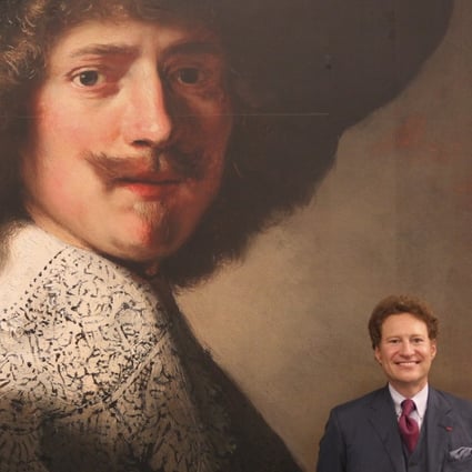 Thomas Kaplan with a poster of one of his paintings, Portrait of Antonie Coopal, by Rembrandt van Rijn and workshop, at the Long Museum, in Shanghai. Picture: Simon Song