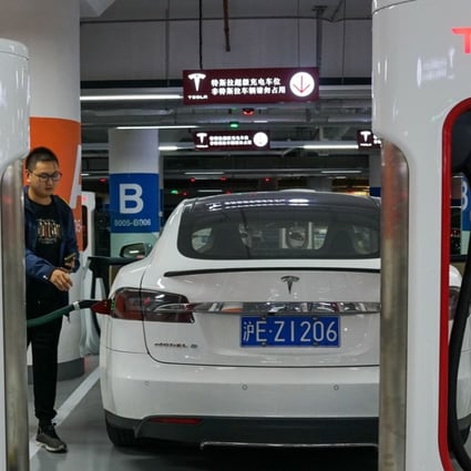 People charge their Tesla vehicles at a charging station inside a mall in Shanghai. Photo: AFP