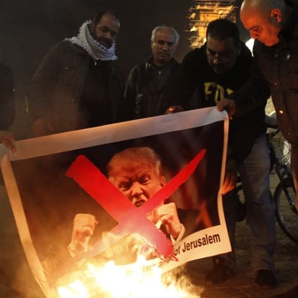 Palestinian protesters burn pictures of US President Donald Trump at the manger square in Bethlehem on December 5, 2017 after Trump announced his plan to recognise Jerusalem as Israel’s capital on Wednesday. Photo: AFP