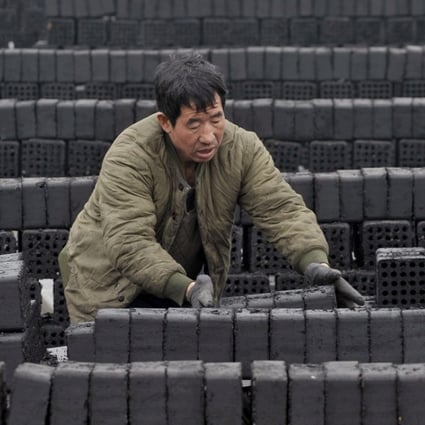 A worker prepares coal briquettes at a plant in Shenyang in northeastern China. Photo: EPA