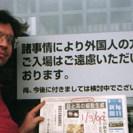 Debito Arudo in front of a Japanese bathhouse with a sign saying ‘Japanese Only’. Photo: Julian Ryall