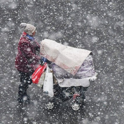 A woman pushes a baby carriage through heavy snow in Yantai in Shandong province earlier this month. The rush to convert from coal heating systems to gas has led to shortages of the fuel in China’s north. Photo: Agence France-Presse