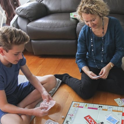 Alison Middleton (centre), a wellness ambassador at Health Nation in Central, enjoys a game of Monopoly with her son Alex and husband, Steve, in the lead-up to Christmas. Photo: Roy Issa