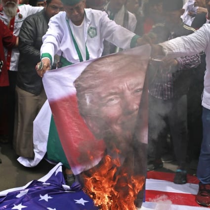 Protesters in Jakarta, Indonesia, burn a poster of US President Donald Trump during a rally outside US Embassy in the city, on December 11, to denounce Trump's decision to recognise Jerusalem as Israel's capital. Photo: AP