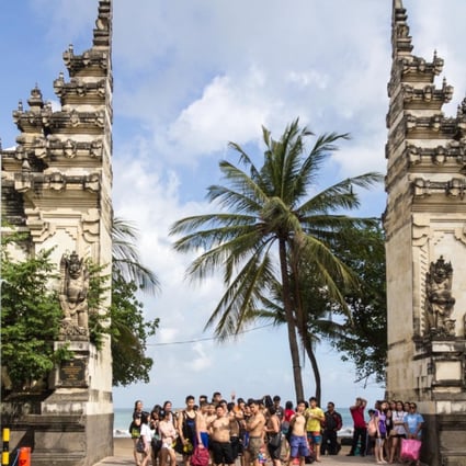 Chinese tourists at the entrance to Kuta Beach in Bali. Photo: Alamy