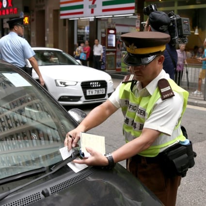 A traffic warden issues a ticket for illegal parking in Tsat Tsz Mui Road in North Point. Photo: Sam Tsang