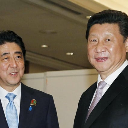 Shinzo Abe with Xi Jinping at the start of their bilateral meeting on the sidelines of the Asian-African Conference in Jakarta. Photo: Reuters