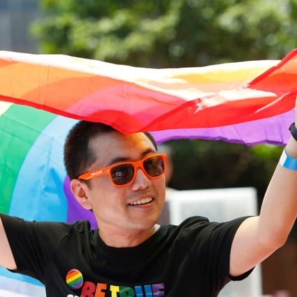 A man holds a rainbow flag after taking part in the Pride Run in Shanghai. The media regulator faces a legal challenge over rules that ban content depicting gay relationships. Photo: AFP