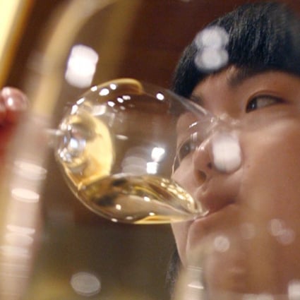 A woman drinks white wine during a wine-tasting event in Beijing. Technology start-up eDaijia, which runs a popular mobile app that links inebriated car owners with substitute drivers, has terminated a service that allowed users to summon surrogate drinkers. Photo: Reuters