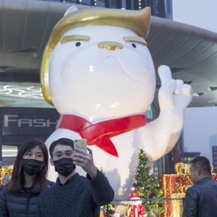 A statue with a likeness to US President Donald Trump heralds the Year of the Dog outside a shopping centre in northern China. There are signs the Trump administration will take some sort of tough trade action against China. Photo: AFP