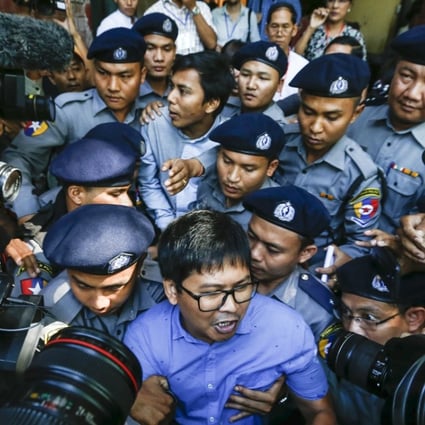 Reuters journalists Wa Lon, centre front, and Kyaw Soe Oo, centre back, are escorted by police as they leave the court in Yangon, Myanmar. Photo: EPA