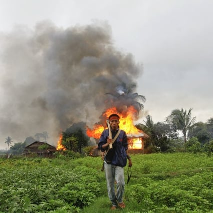 A Buddhist Rakhine man walks away from houses torched during fighting between Rakhine and Muslim Rohingya communities in the Rakhine State capital of Sittwe. Picture: Reuters