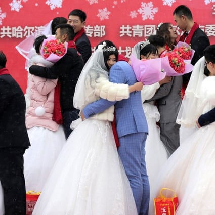 Newlyweds embrace at a collective wedding ceremony in China. A change to the legal definition of joint marital liability, which takes effect on Thursday, is designed to protect spouses from their prodigal partners. Photo: EPA-EFE
