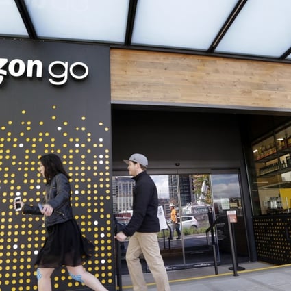People walk past an Amazon Go store in Seattle. Amazon Go shops are convenience stores that don't use cashiers or checkout lines, but use a tracking system that of sensors, algorithms, and cameras to determine what a customer has bought. Photo: AP
