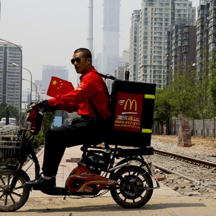 A delivery man rides past residential buildings in Beijing. Ele.me said Chinese consumers placed 8.86 million online orders for congee with minced pork and preserved egg in 2017, making it the most popular takeaway in the country. Photo: AP