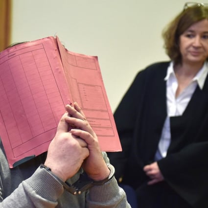 File photo taken on February 26, 2015 shows German former male nurse known as Niels H. hiding his face behind a folder as he waits next to his lawyer Ulrike Baumann (R) before the start of a hearing. Prosecutors said on January 22, 2018, the nurse faces 97 more counts of murder. Photo: DPA via AFP