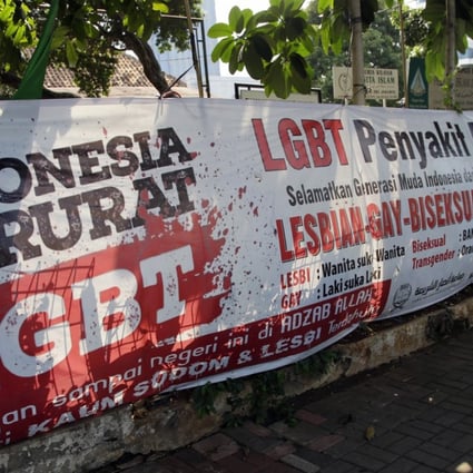 A man walks past an anti-LGBT banner erected by an ultra-conservative Islamic group in Jakarta. Photo: AP