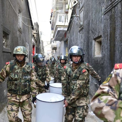 Paramilitary policemen carry crystal meth seized in Lufeng in Guangdong province. Narcotics are one of many areas targeted in Beijing’s new campaign. Photo: AFP 