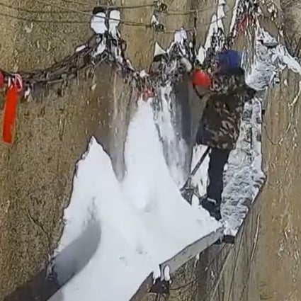Zhang Dongdong gets to work clearing snow from a narrow pathway on Huashan in northwestern China. Photo: News.163.com