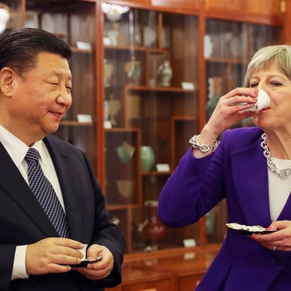 Theresa May drinks tea with Xi Jinping during a ceremony in Beijing on Thursday. Photo: Bloomberg