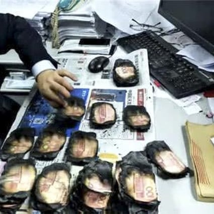 A Bank of Chengdu employee checks some of the badly burnt banknotes. Photo: Thepaper.cn