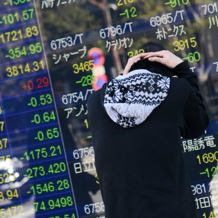 A man reacts after looking at an electronic stock board outside a securities firm in Tokyo, Japan, on Tuesday, Feb. 6, 2018. Japan’s blue-chip Nikkei 225 Stock Average entered a correction as the nation’s shares posted the biggest decline since November 2016, following U.S. peers lower amid rising concern that inflation will force interest rates higher. Photo: Noriko Hayashi/Bloomberg