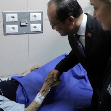 Chinese Ambassador in Damascus Qi Qianjin and World Health Organisation representative Elizabeth Hoff speak to a patient as they tour a hospital in Damascus, Syria, on Sunday. Photo: EPA