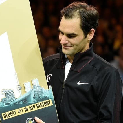 Roger Federer holds a trophy celebrating his milestone achievement after beating Robin Haase in their Rotterdam quarter-final. Photo: AFP