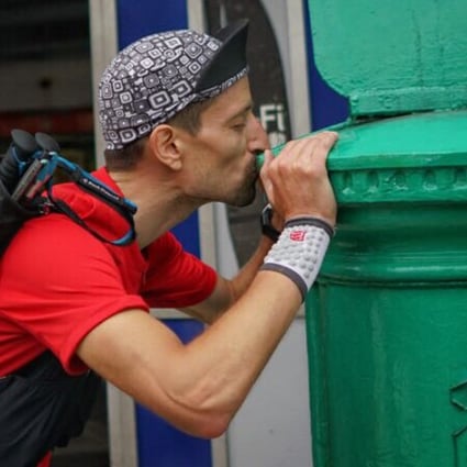 Salomon Wettstein kisses the postbox in Mui Wo after becoming the first ‘finisher’ in this year’s Four Trails Ultra Challenge. Photos: Lloyd Belcher Visuals
