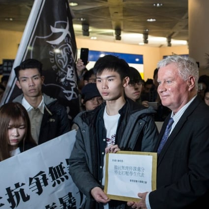 Clayton MacKenzie (second right), a representative of Baptist University, receives a petition letter from a student demonstrator, in Hong Kong on January 26. Hundreds of students protested on the day amid tensions over compulsory testing of Mandarin, the dominant language in mainland China, for graduation. Photo: AFP