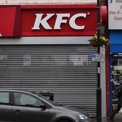 Pedestrians walk past a closed KFC fast food store in south London on February 19. Photo: AFP