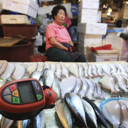 A worker using a Geiger counter checks for possible radioactive contamination at Noryangjin Fisheries Wholesale Market in Seoul, South Korea. Photo: AP