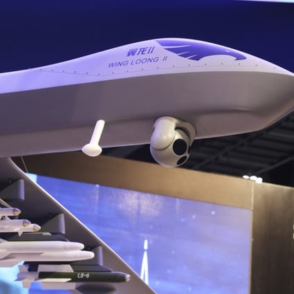 A model of a Wing Loong II weaponised drone hangs above the stand for the China National Aero-Technology Import and Export Corp at a military drone conference in Abu Dhabi. Photo: AP