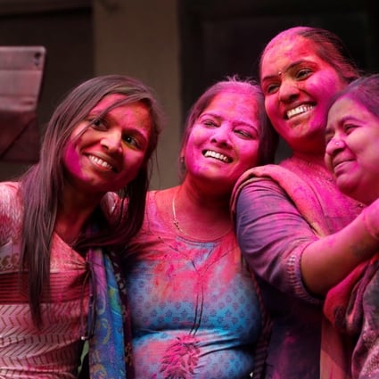Indian teachers smeared with coloured powder take a selfie during Holi celebrations at a school in Ahmadabad on Thursday. Photo: Reuters